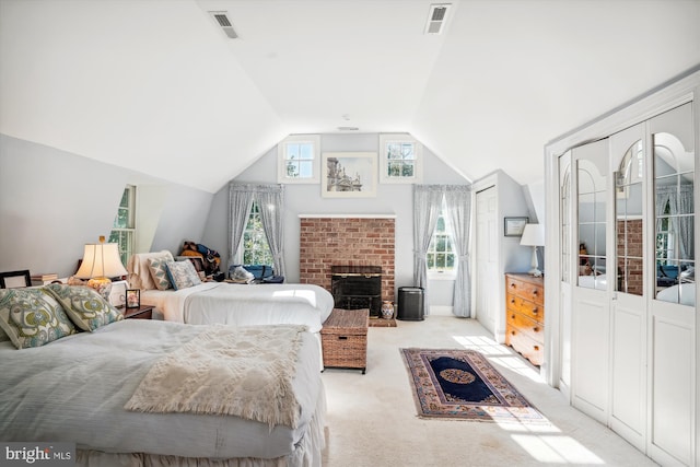 carpeted bedroom with lofted ceiling, a fireplace, and multiple windows