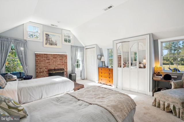 carpeted bedroom with lofted ceiling, a fireplace, and multiple windows