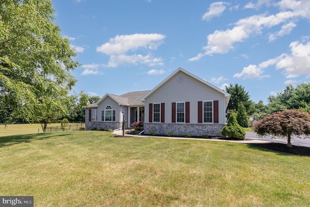 single story home with stone siding, fence, and a front yard