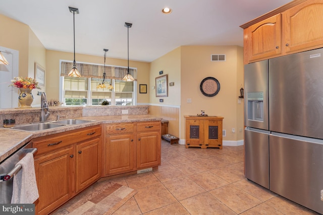 kitchen with visible vents, decorative light fixtures, stainless steel appliances, a sink, and light tile patterned flooring