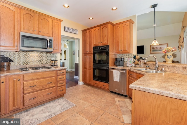 kitchen featuring pendant lighting, stainless steel appliances, light countertops, light tile patterned flooring, and a sink