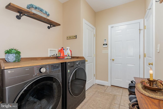 laundry area featuring light tile patterned floors, visible vents, separate washer and dryer, laundry area, and baseboards