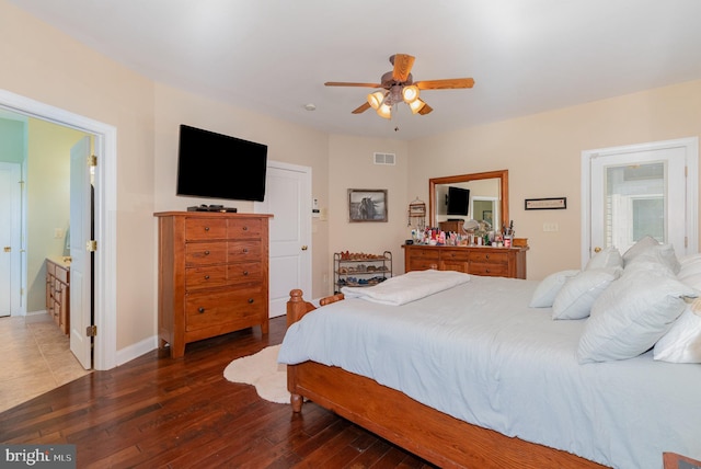 bedroom featuring a ceiling fan, visible vents, baseboards, and hardwood / wood-style flooring