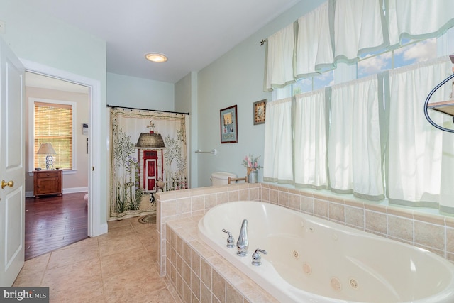 bathroom with a whirlpool tub and tile patterned floors