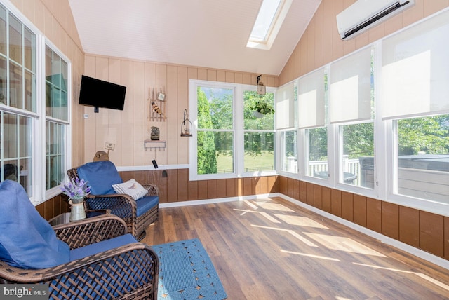 sunroom with an AC wall unit and lofted ceiling with skylight