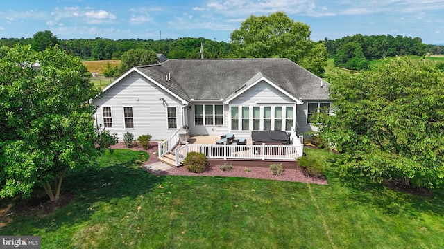 back of property with a yard and a shingled roof