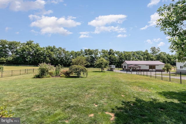 view of yard featuring a rural view, fence, and an outdoor structure