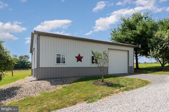 view of home's exterior with a detached garage, an outbuilding, and a yard