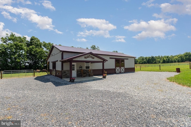 view of front of house with an outbuilding, stone siding, and an exterior structure