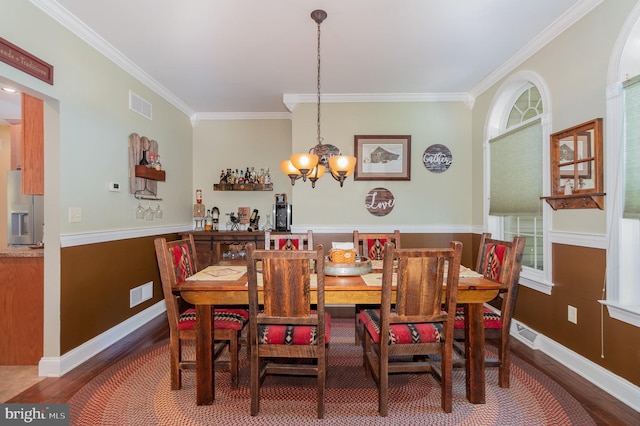 dining area with ornamental molding, visible vents, and wood finished floors