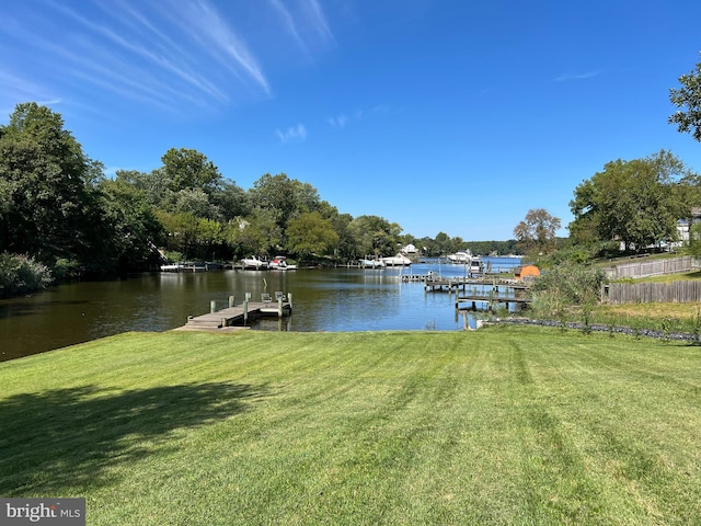 dock area featuring a water view and a lawn