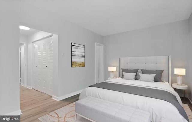 bedroom with light hardwood / wood-style flooring and a closet