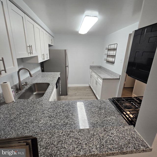 kitchen featuring white cabinets, light wood-type flooring, and sink