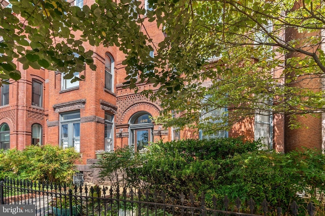 view of front of house with brick siding and fence