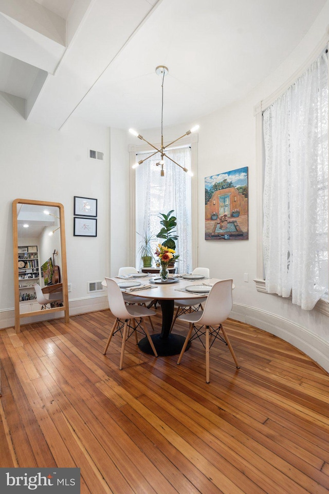 dining area featuring hardwood / wood-style flooring and an inviting chandelier