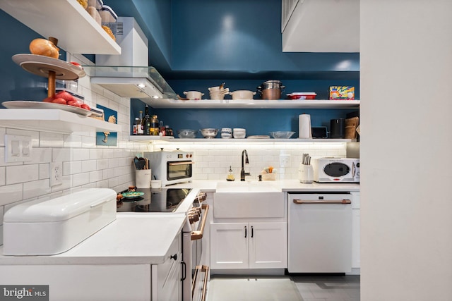 kitchen featuring white cabinetry, white appliances, tasteful backsplash, exhaust hood, and sink