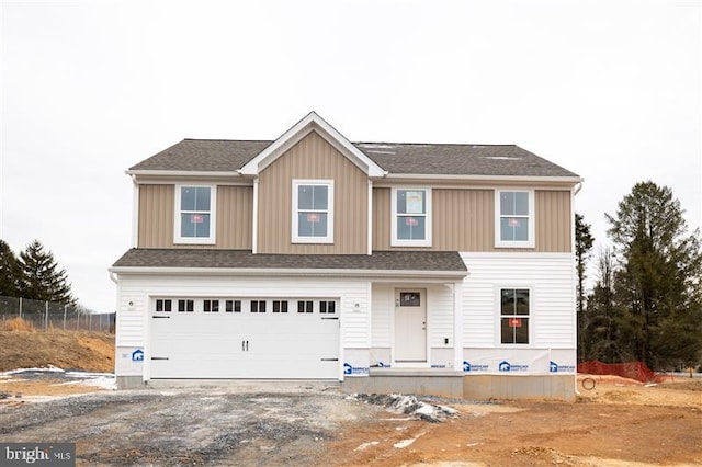 view of front of property with board and batten siding, a shingled roof, a garage, and fence