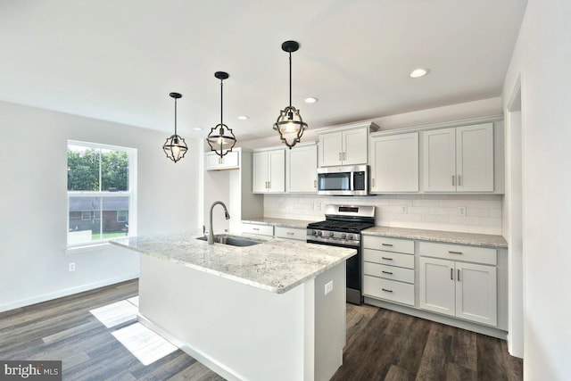 kitchen with appliances with stainless steel finishes, sink, decorative backsplash, and dark wood-type flooring