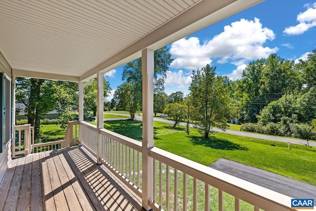 wooden deck with a porch and a lawn