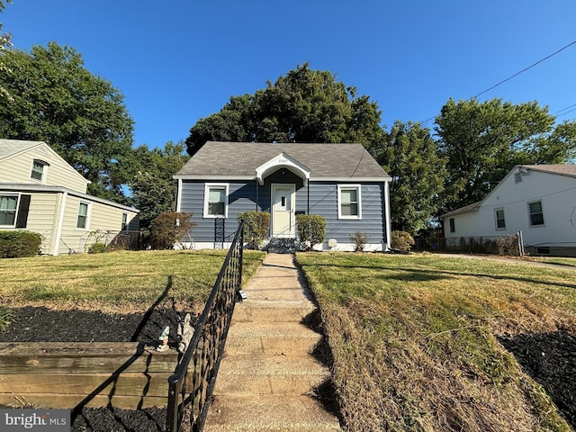 bungalow-style house featuring a front lawn and fence