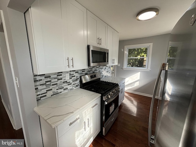 kitchen featuring stainless steel appliances, light stone countertops, dark wood-style floors, and decorative backsplash