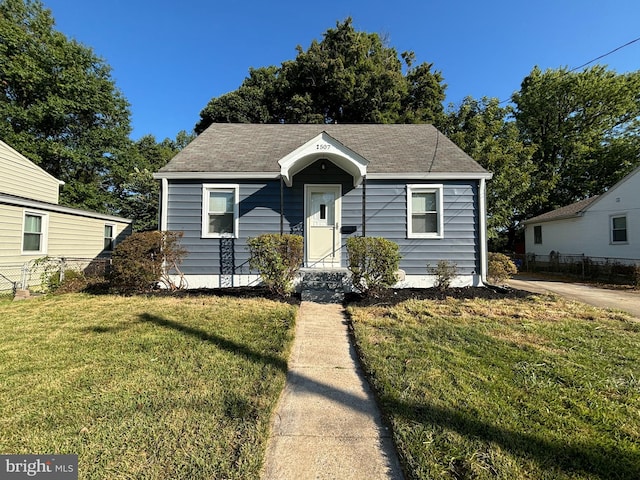 bungalow-style house featuring a front lawn