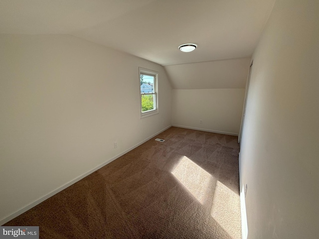 additional living space with lofted ceiling, visible vents, baseboards, and carpet floors