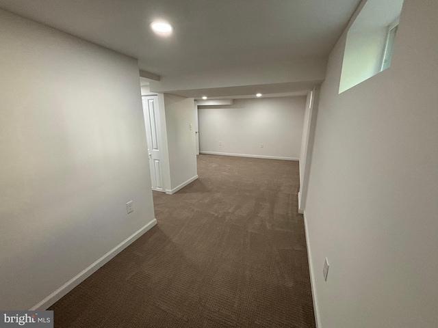 hall with recessed lighting, baseboards, and dark colored carpet