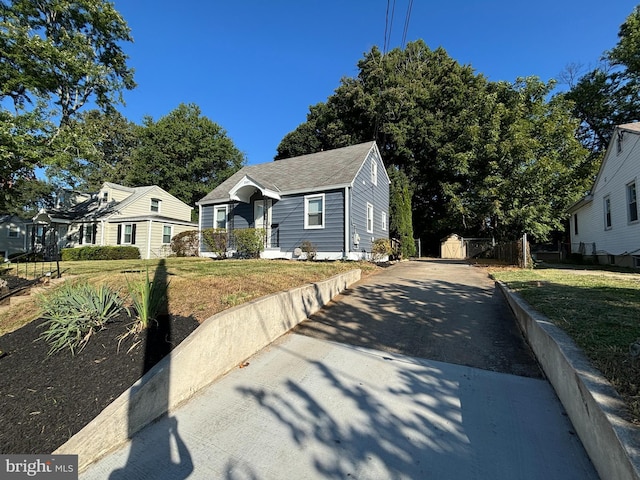 bungalow featuring driveway, a front yard, and fence