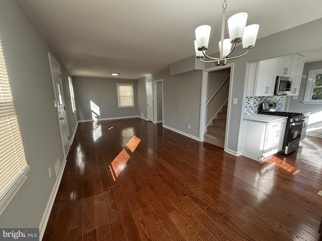 interior space featuring visible vents, baseboards, dark wood finished floors, a chandelier, and stairs