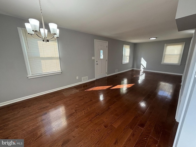 interior space featuring an inviting chandelier and dark hardwood / wood-style flooring