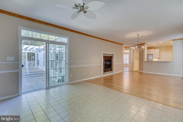 unfurnished living room with ceiling fan with notable chandelier, crown molding, and light hardwood / wood-style flooring