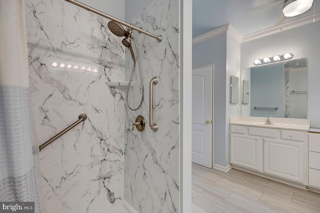 bathroom featuring ceiling fan, a tile shower, crown molding, and vanity