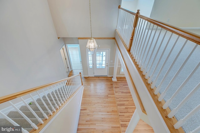 entryway featuring a notable chandelier, hardwood / wood-style floors, and a high ceiling