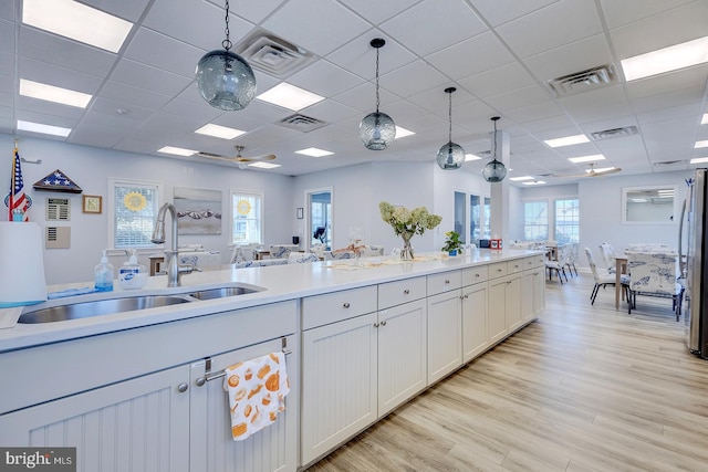 kitchen featuring pendant lighting, light hardwood / wood-style flooring, a wealth of natural light, and sink