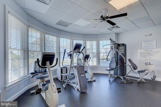 exercise room with a drop ceiling and ceiling fan