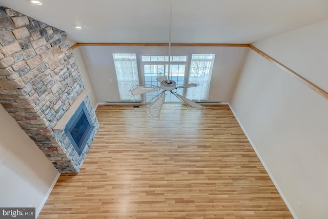 dining space featuring a fireplace, ornamental molding, light wood-type flooring, and ceiling fan