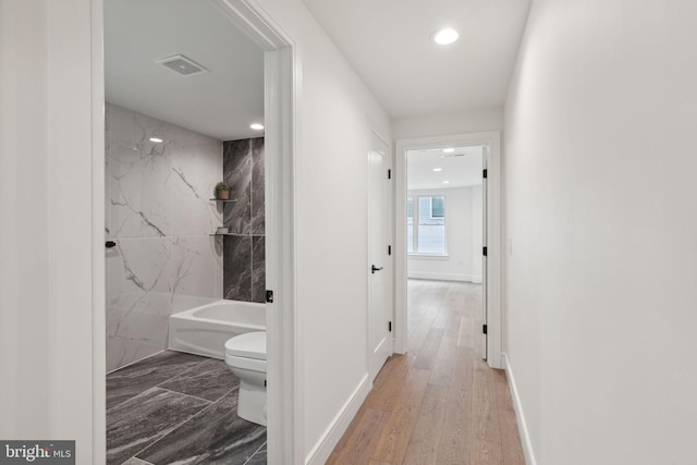 corridor with hardwood / wood-style floors