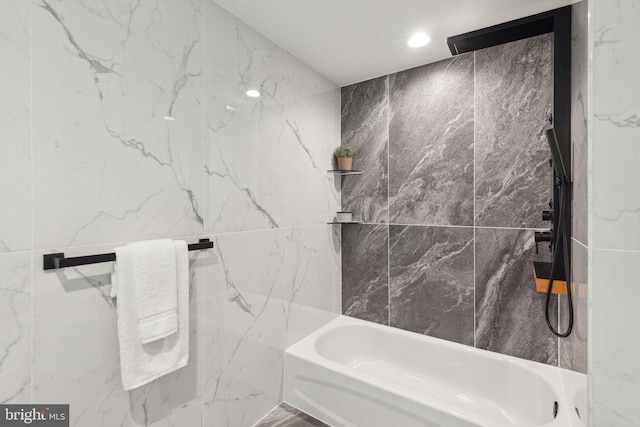 bathroom featuring tiled shower / bath combo and tile walls