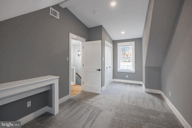 bonus room with vaulted ceiling with beams and light carpet