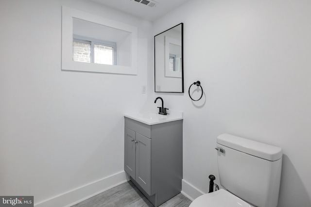 bathroom with vanity, wood-type flooring, and toilet