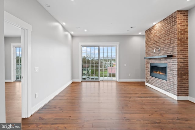 unfurnished living room with a fireplace and dark wood-type flooring