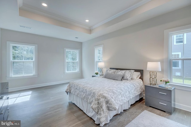 bedroom with multiple windows, crown molding, and light wood-type flooring