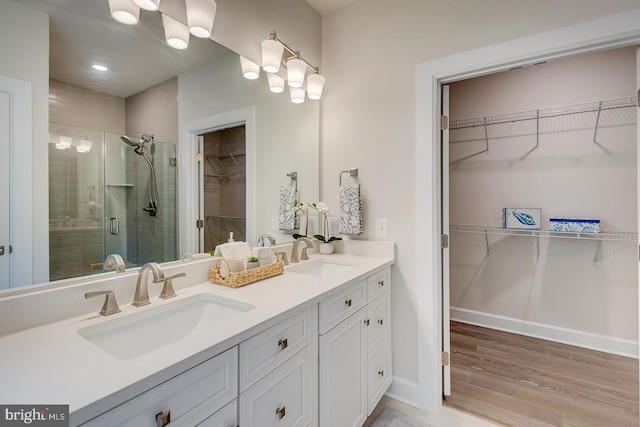 bathroom featuring hardwood / wood-style flooring, vanity, and a shower with shower door