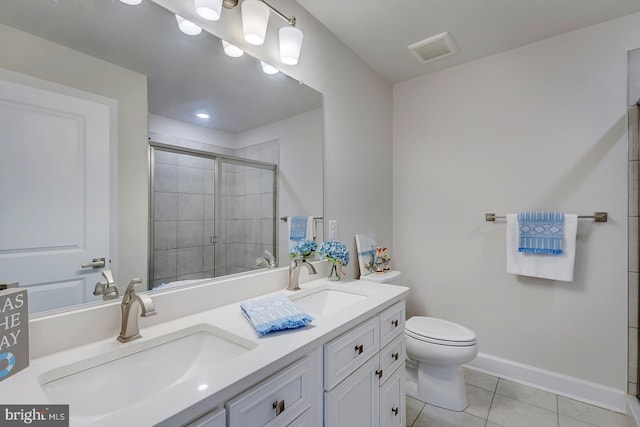 bathroom with tile patterned floors, a shower with shower door, vanity, and toilet