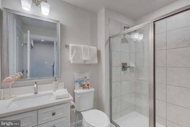 bathroom featuring walk in shower, vanity, and toilet