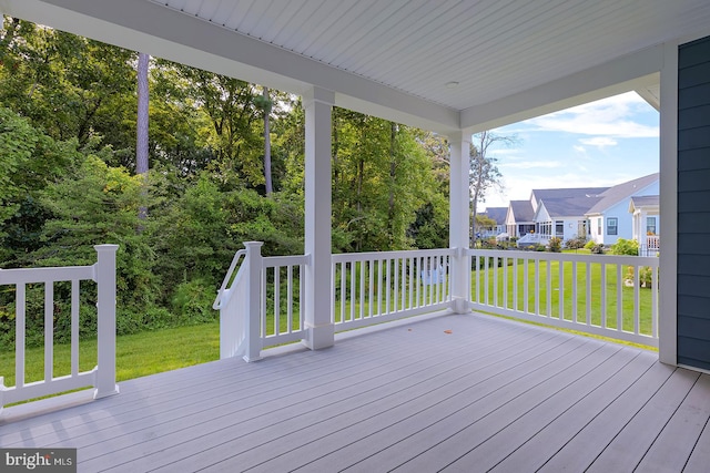 wooden terrace featuring a yard