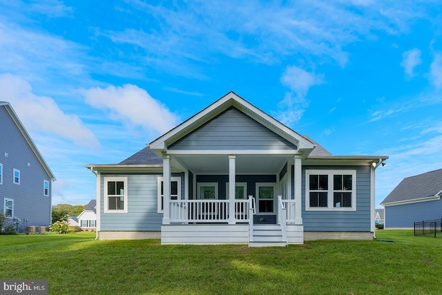 back of property with a lawn and covered porch