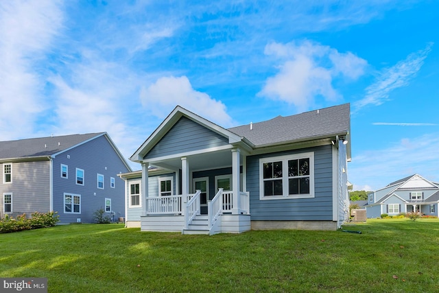 view of front of house featuring a front lawn, covered porch, and central AC unit