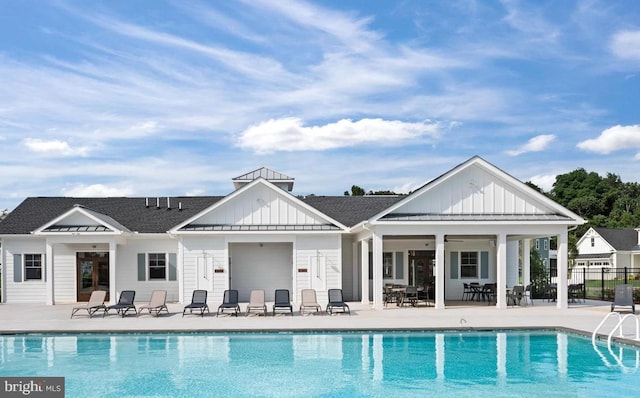 rear view of house with a fenced in pool and a patio